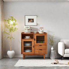 a living room with a white couch and wooden cabinet in it's center area