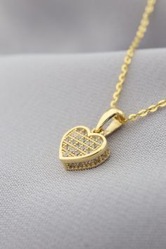 Adorn yourself with elegance and love with our enchanting Gold Heart Pendant Necklace. This dazzling piece features intricate details and sparkling stones that capture the essence of romance and charm. The heart-shaped pendant exudes a sense of sentiment and beauty, making it a perfect accessory to express your affection for someone special. Whether it's a gift for yourself or a loved one, this necklace is an ideal choice to celebrate love and emotions. Embrace the magic of this pendant as it sh Heart Pendant Jewelry With Sparkling Stones For Gifts, Heart-shaped Jewelry With Sparkling Stones For Gifts, Gift Heart Pendant Jewelry With Sparkling Stones, Diamond Necklace For Valentine's Day Gift, Fine Jewelry Heart Pendant Necklace For Wedding, Gold Heart-shaped Jewelry With Sparkling Stones, Valentine's Day Diamond Accented Necklace For Her, Heart-shaped Gold Jewelry With Sparkling Stones, Brilliant Cut Necklace For Valentine's Day Gift