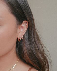 a close up of a person wearing some kind of earring with gold chains on it