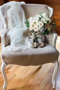 a chair with a bouquet of flowers on it and a veil draped over the back