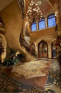 an ornate entryway with chandelier and stairs leading up to the second floor