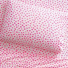 pink and white polka dot sheet set with matching pillowcases on top of each other