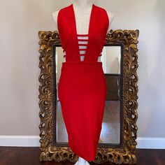 a mannequin dressed in a red dress and white shoes with a mirror behind it