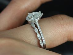 a close up of a person's hand with a diamond ring on their finger