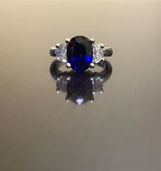 Dekara Designs Collection Metal- 90% Platinum, 10% Iridium. Stones- 1 Natural Untreated 3.88 Carat Oval Cut Ceylon Blue Sapphire. 2 Moon Cut Diamonds, F-G Color VS1 Clarity 0.77 total carats This ring is a size 6, but could be sized up or down a few sizes. This ring could be made in your specific size within 5-10 business days. Could take a little more time due to the ceylon sapphire being a rare stone. The sapphire may be a bit smaller or bigger. We can make the same design in a smaller or bigg Classic Blue Sapphire Diamond Ring, Formal Blue Sapphire Ring Gia Certified, Blue Gia Certified Diamond Ring For Formal Occasions, Blue Oval Sapphire Ring With Vvs Clarity, Blue Sapphire Three Stone Ring With Diamonds, Oval Blue Sapphire Ring With Vvs Clarity, Blue Lab-created Sapphire Diamond Ring For Promise, Elegant Blue Sapphire Three Stone Ring, Blue Sapphire Three-stone Promise Ring