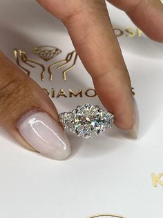 a woman's hand with a diamond ring on her finger