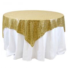 a gold and white table cloth on top of a round table with a golden sequin