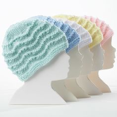 four knitted hats sitting on top of a white mannequin's head