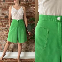 "Vintage 1960s/1970s Kelly green culottes, featuring a high waist, cropped wide leg with a white  button waist and white contrast stitching. They have a patch pocket at each hip and a zipper fly. Expand for more details and measurements.   They are in good/great condition. There is a small run in the fabric near the button hole (See 3rd last photo).   JC Penney Fashions 50% Cotton, 50% Polyester Likely made in USA Tag sie 11 Fits a 27\" Waist Measurements are done with garment laying flat and ar Wide Leg Buttoned Shorts For Spring, Casual Wide Leg Shorts With Buttons, Green Wide-leg Shorts With Pockets, Green Wide Leg Shorts With Pockets, Green Cotton Knee-length Bottoms, Summer Green Pants With Buttons, Retro Spring Bottoms With Button Closure, Green Summer Pants With Button Closure, Summer Green Pants With Button Closure