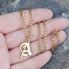 "~Personalized initial necklace. ~18k gold plated Stainless steel. ~Water, heat & sweat resistant. ~No discolouration or tarnishing (no green skin). ~Hypoallergenic. Please select initial & chain length from the drop down menus. The length does not include the letter pendant. The model in is wearing an 18\" necklace. Components: Chain - 18k gold plated stainless steel. Pendant - 18k gold plated stainless steel, approx 17mm (size varies). Your item will arrive in a drawstring pouch - Ready for Gift Giving!" Gold Letter Pendant For Men, Gold Initial Necklace In Stainless Steel, Gold Stainless Steel Initial Necklace, Initial Necklace For Men, Gold Letter Pendants, Boyfriend Necklace, Green Skin, Boys Jewelry, Gold Chains For Men