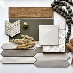 a white table topped with lots of different types of tiles and wood beads on top of it