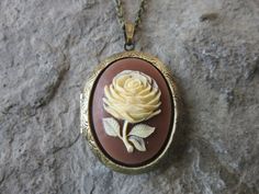 "Gorgeous rose cameo bronze or gold plated locket Stunning detail and colors!! The bronze locket is 2\" long, please see the photos, and has stunning Victorian etching on both the front and back. It can hold two photos or a treasured keepsake The bronze matching chain is 24\" rolo link chain, with a lobster claw clasp, and the gold is a 24 \" gold plated snake chain with a lobster claw clasp. Please do visit my shop, I am always creating something new and unique, and I will always honor special Cameo Locket, Unique Locket, Cameo Brooch, Pin Pendant, Wedding Bridesmaid, Stunning Necklace, Locket Necklace, Wedding Bridesmaids, Snake Chain