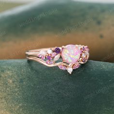 an opal and pink sapphire ring set in rose gold with diamonds on the sides