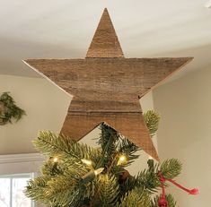 a wooden star hanging from the top of a christmas tree