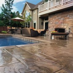 an outdoor pool with patio furniture next to it