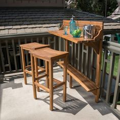 two wooden stools sitting on top of a balcony next to a table and chairs