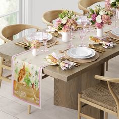 the table is set with flowers and plates