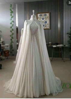 a white wedding dress on display in a room