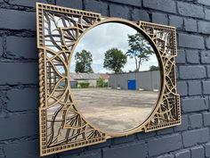 a round mirror mounted to the side of a brick wall next to a parking lot