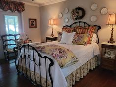 a bedroom with a bed, lamps and pictures on the wall