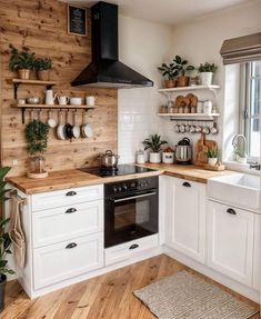 a kitchen with white cabinets and wooden shelves filled with potted plants on the wall