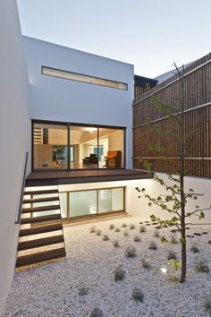 a modern house with an outdoor patio and stairs leading up to it