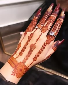 a woman's hand with henna tattoos on it