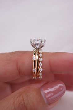 a woman's hand holding an engagement ring with two rows of diamonds on it