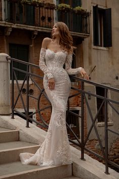 a woman in a wedding dress standing on some stairs