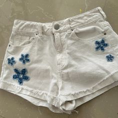 Very Different Pacsun Shorts. Crisp White With Denim Flowers. Look Much Nicer In Person. Five Pocket Jean Style. Frayed, Cuffed Hem. Waist - Side To Side - 12 1/2 Inches - Length - Top To Bottom - 12-13 Inches Pristine Condition - Never Worn (Too Small), Cleaning Closet! Size On Tag - 25 Inches (True To Size) Trendy White Denim Shorts, Trendy High-waist White Jean Shorts, Trendy High Waist White Jean Shorts, Summer Cotton Jean Shorts, Trendy White Cutoff Jean Shorts, Blue Cotton Summer Jean Shorts, Casual White High Waist Jean Shorts, Casual High-waist White Jean Shorts, Trendy Cotton Beach Bottoms