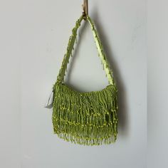 a green purse hanging from a hook on a wall