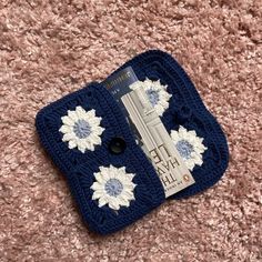 a crocheted blue and white case with flowers on it sitting on the carpet