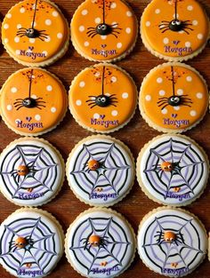 decorated cookies are arranged on a table with spider webs and pumpkins in the center