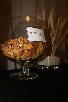 a glass bowl filled with cereal on top of a table next to a sign that reads pub mix