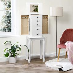 a living room with a chair, table and two boxes on top of each drawer