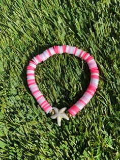 A multicolored pink bracelet with a starfish charm. Pink Preppy Bracelet, Pink Bohemian Strand Friendship Bracelets, Bohemian Pink Strand Friendship Bracelets, Pink Starfish Jewelry For Gift, Summer Bracelets With Starfish Charm, Starfish Charm Bracelets For Beach Season, Pink Starfish Charm Jewelry, Pink Star-shaped Jewelry With Starfish Charm, Pink Star Jewelry With Starfish Charm