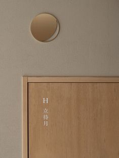 a wooden door with the word hi written on it and a round hole in the wall