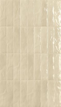 a white tile wall that has been painted with different shades of beiges and browns