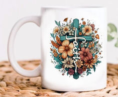 a white coffee mug with flowers and the word faith on it sitting on a wicker table