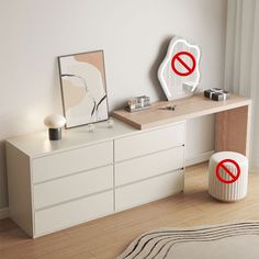 a white dresser sitting next to a mirror on top of a wooden table in a room