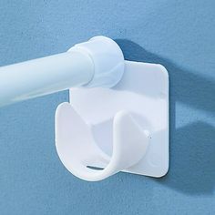 a white toilet paper dispenser attached to a wall with a blue background