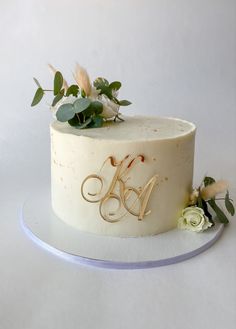 a white cake with gold lettering and flowers on top