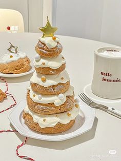 a white table topped with donuts covered in frosting and toppings next to a coffee cup