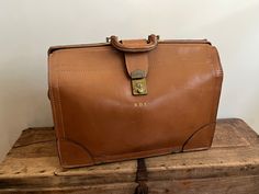 a brown leather bag sitting on top of two wooden boxes