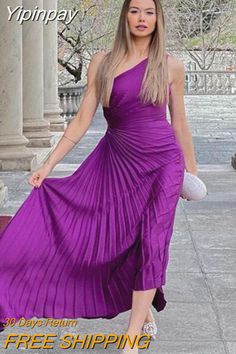 a woman in a purple dress is walking down the street