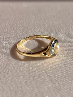 Antique 18k yellow gold ring from the United Kingdom c 1864. This Victorian piece is part of the mourning jewelry movement of the time. The heirloom features three pearls and enamel surrounding the face of the ring. Within the ring, the words "Mary-Ann Buckle died Oct 7, 1864". Great antique condition Size: 5.25 - 5 Weight: 2.0 grams Band: 7.2 mm (front), 1.3 mm (back) Pearls: 3.5 mm x pearl, 2.0 mm x 2 pearls Mary Ann, 18k Yellow Gold Ring, Yellow Gold Ring, Gold Ring, The Face, United Kingdom, Wedding Rings, Yellow Gold, Buckle