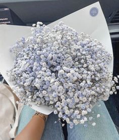 a bouquet of flowers sitting on top of a white piece of paper in someone's lap