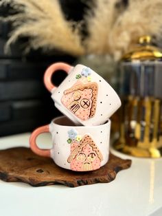 two coffee mugs sitting on top of a wooden tray