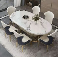 a marble dining table surrounded by white chairs