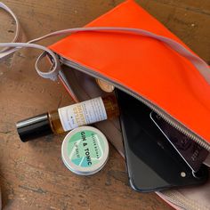 an orange purse and some items on a table